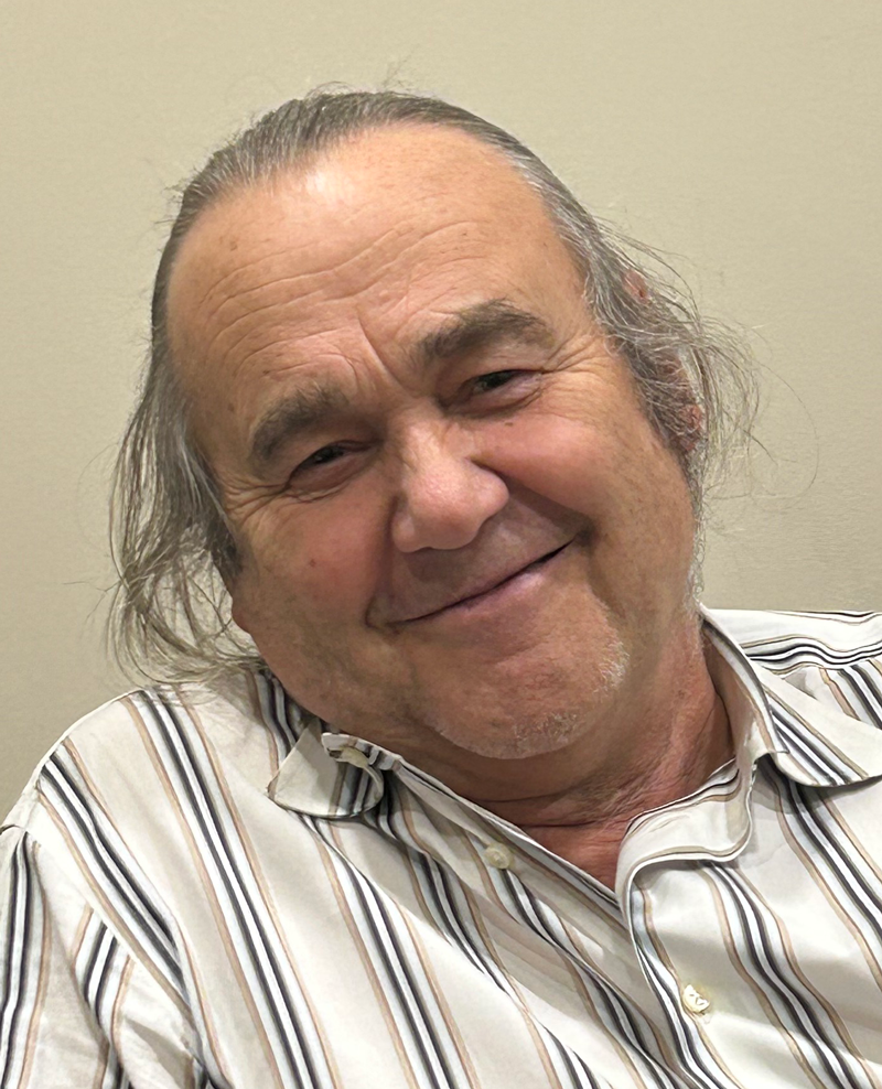 Close up photo of Denis, board chair, smiiling.