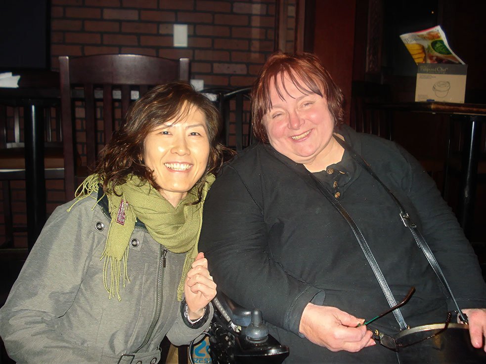 Two people sit close together at the fundraiser, posing for the camera in a casual indoor setting.