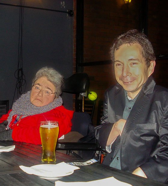 Two people sit close together at the fundraiser, posing for the camera in a casual indoor setting.